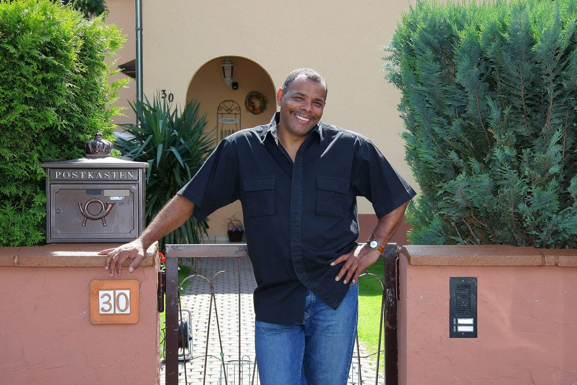 Man smiling in front of house