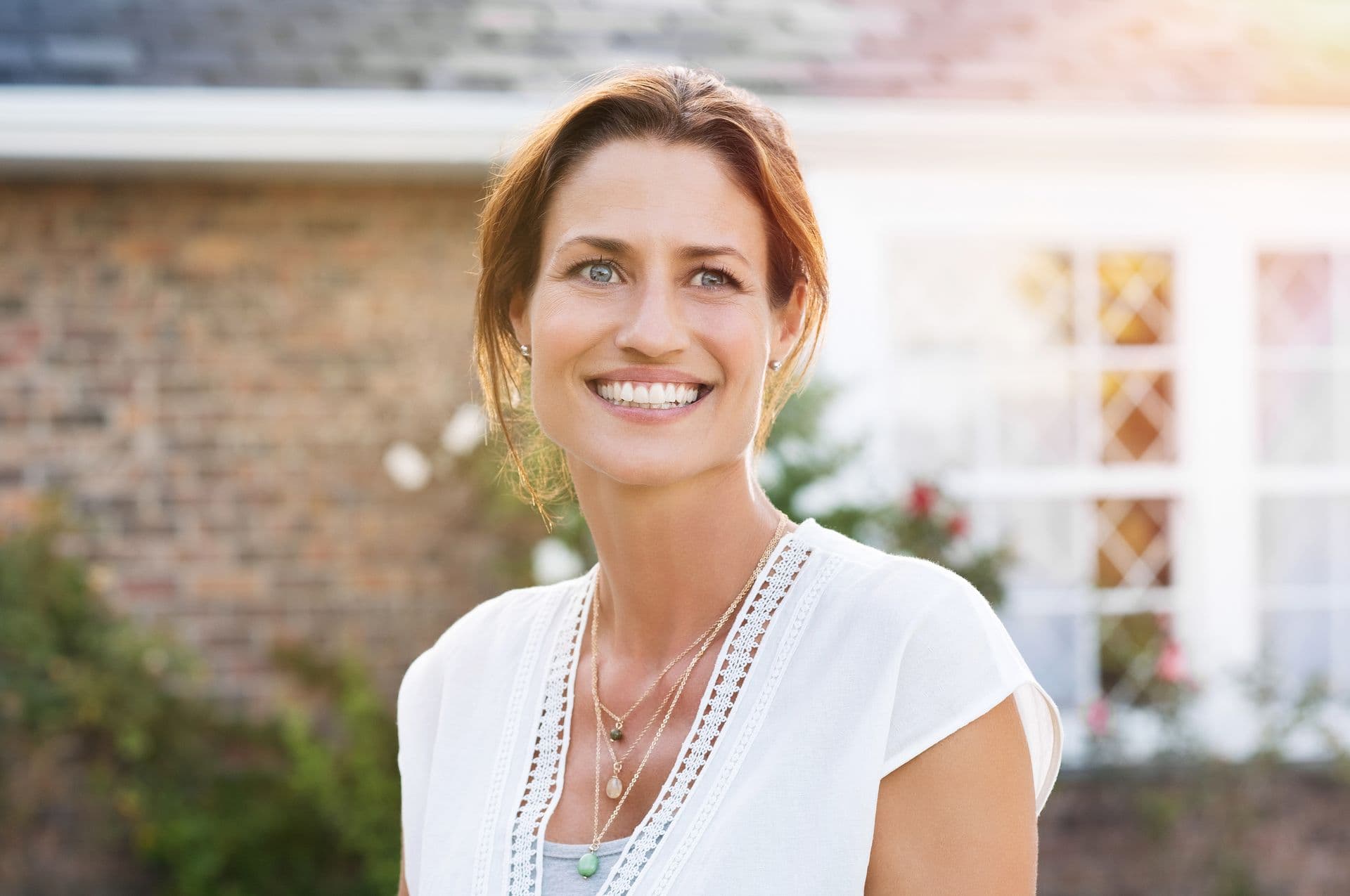 Woman smiling outside house