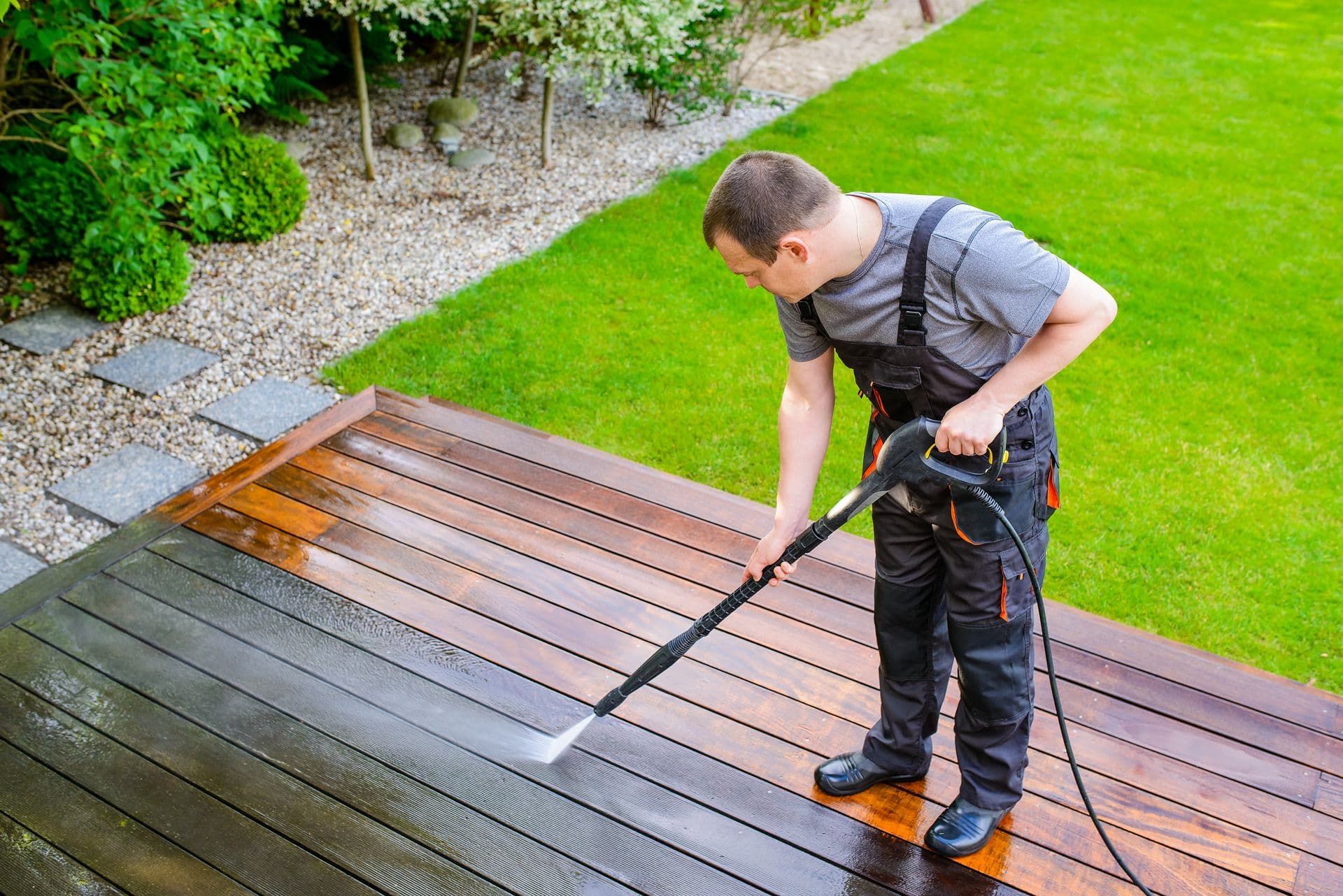 Man power washing deck